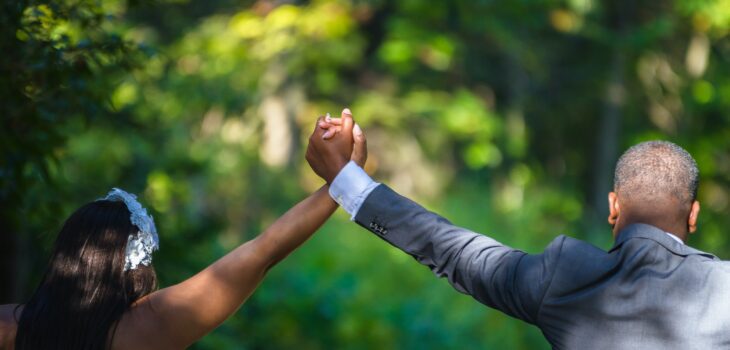 Woman and Man holding hands in air at wedding. 10 Lessons to Transform Your Marriage